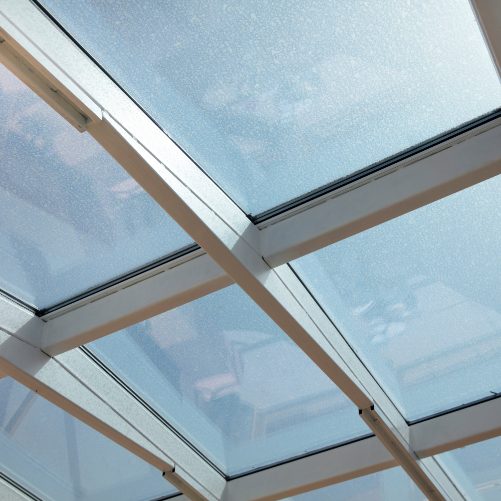 Modern living room with aluminum skylights, allowing natural light to flood the space, creating a bright and airy atmosphere.