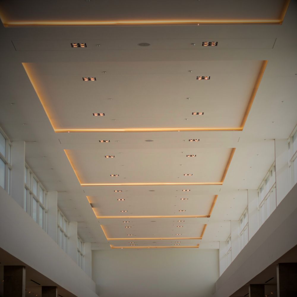 Modern office with a smooth plaster ceiling, featuring recessed lighting and sleek decor